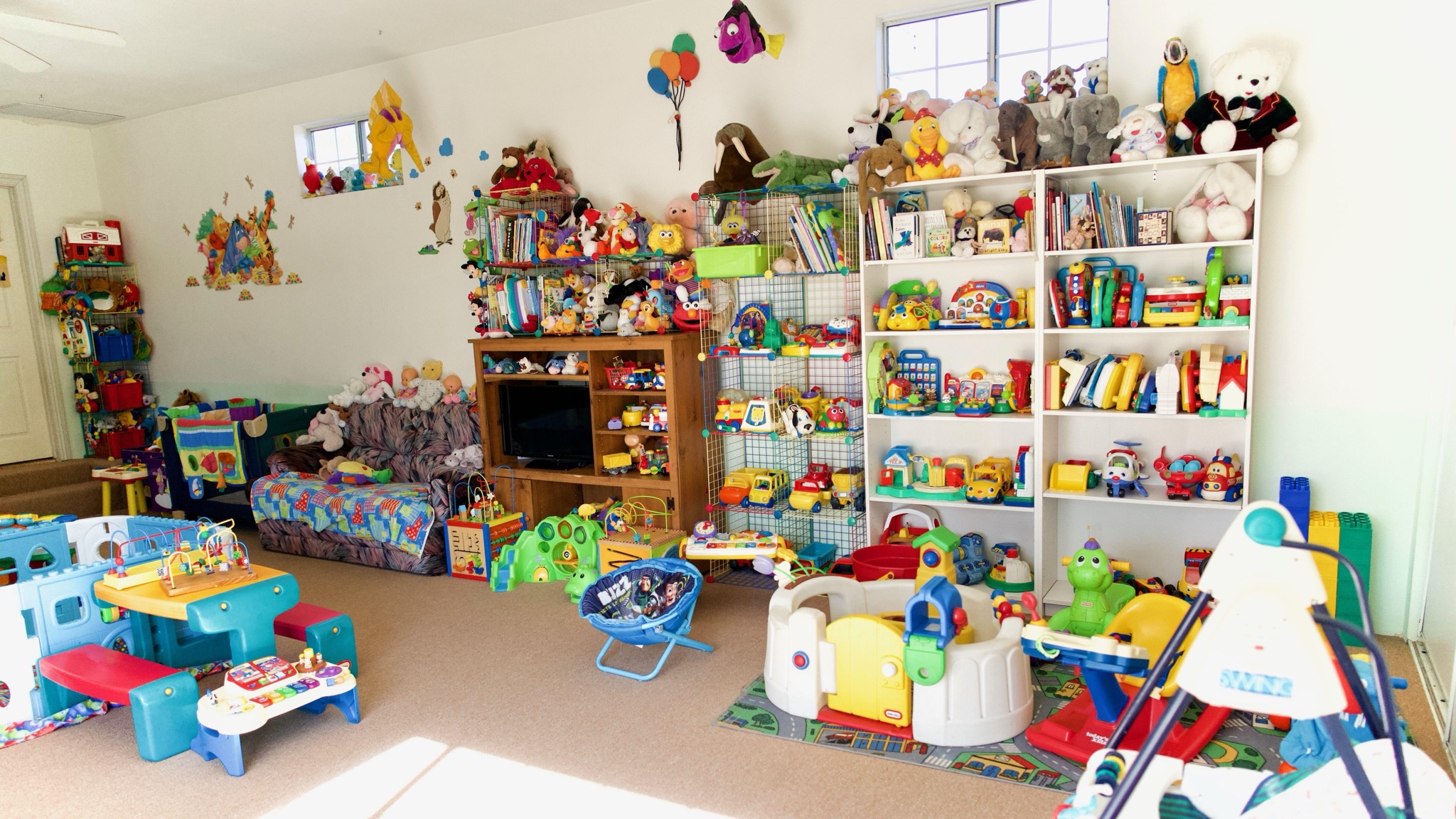 Bright indoor toy wall and play space at Precious Moments Daycare.